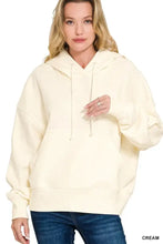 Cream-colored oversized fleece kangaroo pocket hoodie with relaxed fit and matching drawstrings by zenana
