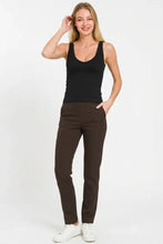 A pair of sleek brown straight-leg trousers with smooth fabric and subtle pockets paired with a ribbed seamless bra padded v-neck tank top