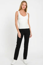 A sleek black slim-fit pant complements the ribbed seamless bra padded v-neck tank top for a smooth silhouette