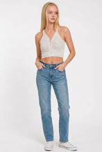 A woman wears a white zenana washed ribbed seamless button v neck tank top with thin straps and button detailing