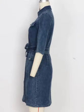 Dark blue denim dress with collar three quarter sleeves and belted waist styled as short sleeve denim dress